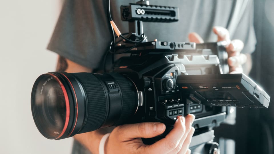 Hands holding a professional Canon cinema camera